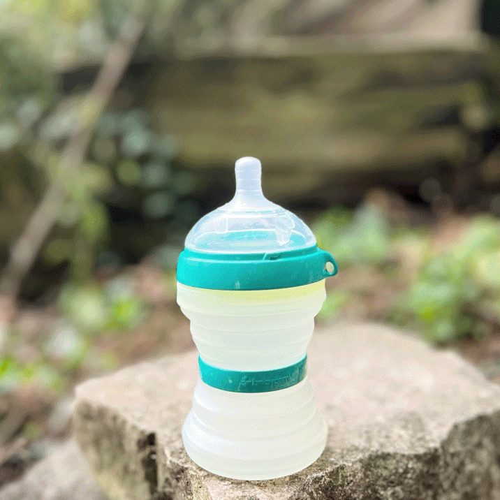 babygami collapsible baby bottle open at 8 oz, standing on a rock outdoors