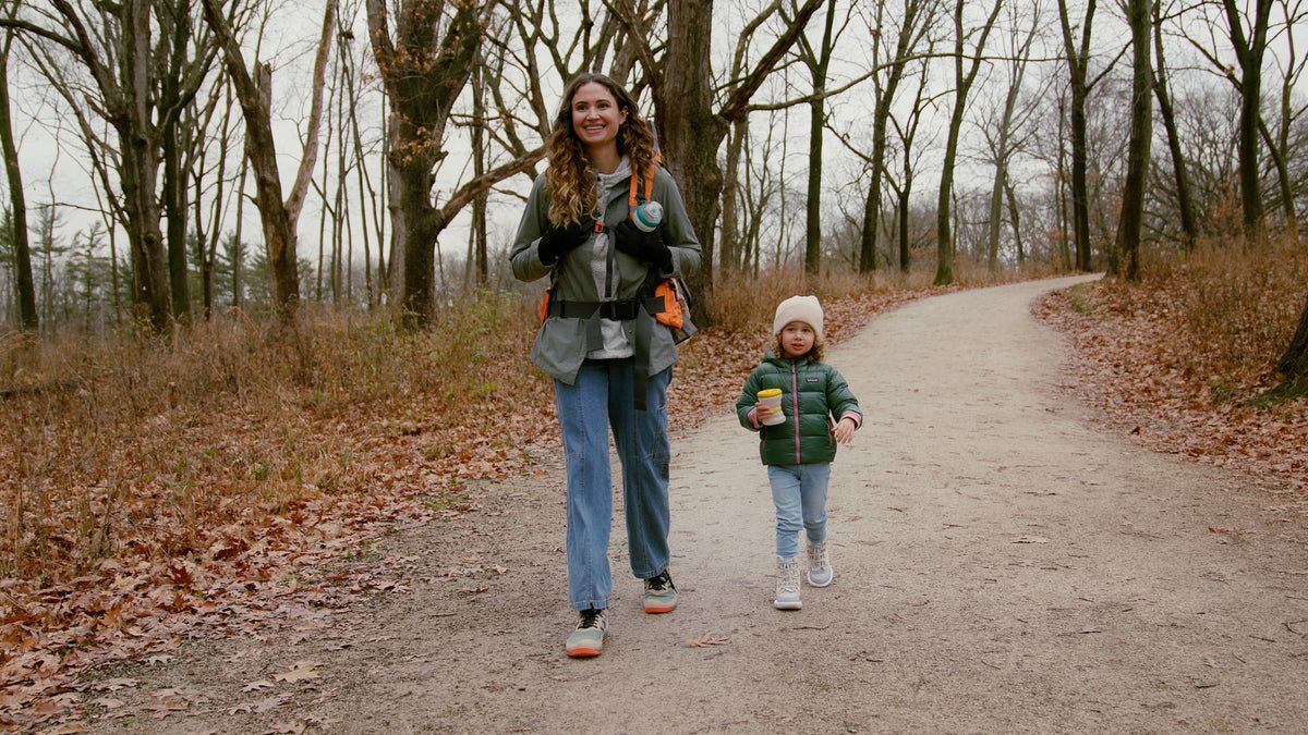 Parent and toddler walking a wooded trail together